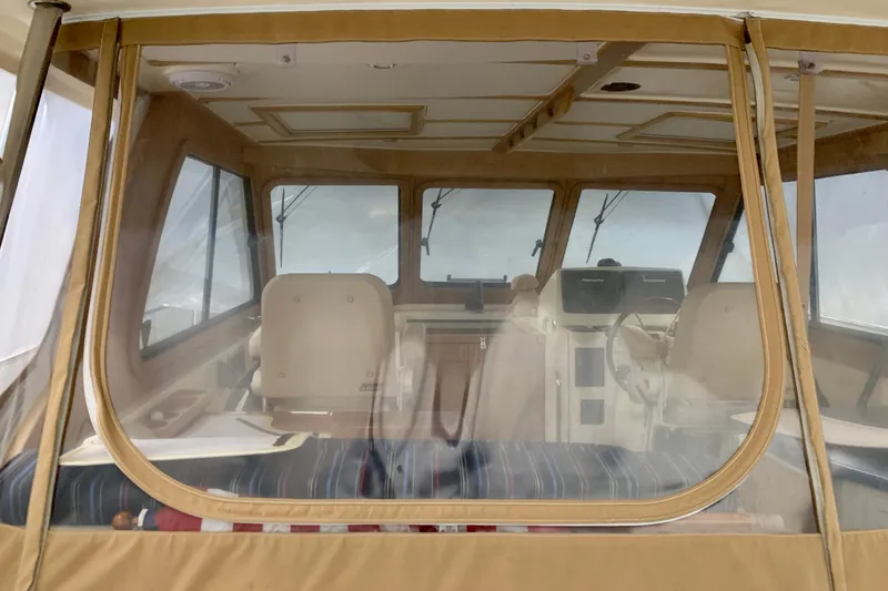 Slide: The Image of 2006 Sabre 38 Hard Top Express interior with beige seating and helm, viewed through clear enclosure. - 41