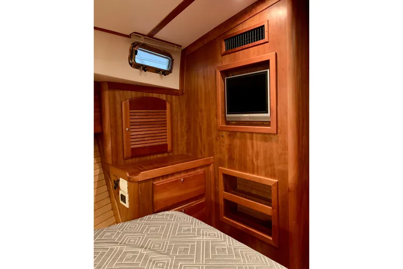 Slide: The Image of 2006 Sabre 38 Hard Top Express cabin interior with wood paneling and built-in TV. - 6