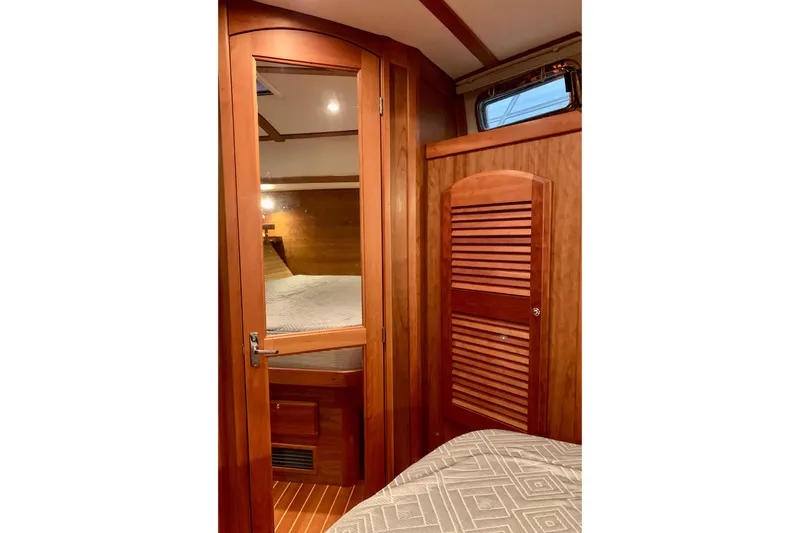 Slide: The Image of 2006 Sabre 38 Hard Top Express cabin interior with wooden door and cozy bed. - 7