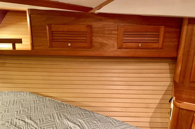 Slide: The Image of Interior of 2006 Sabre 38 Hard Top Express with wooden cabinetry and patterned bedding. - 9