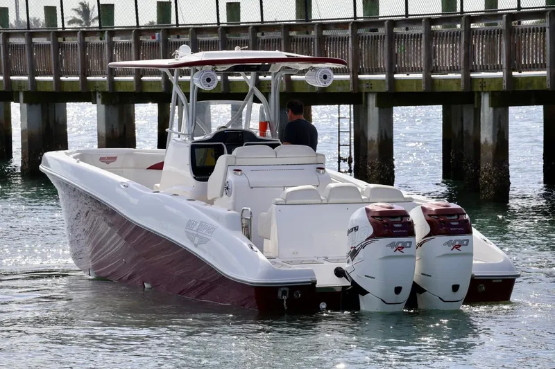 The Image of 2015 Deep Impact 33 boat with twin outboard engines near a wooden pier. - 1