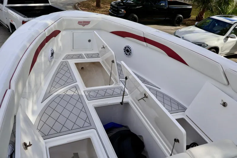 Slide: The Image of 2015 Deep Impact 33 boat interior with open storage compartments and cushioned seating. - 12