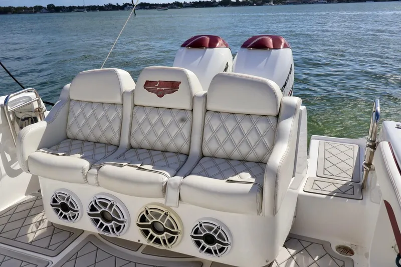 Slide: The Image of Luxury seating on 2015 Deep Impact 33 boat with dual engines and water backdrop. - 4