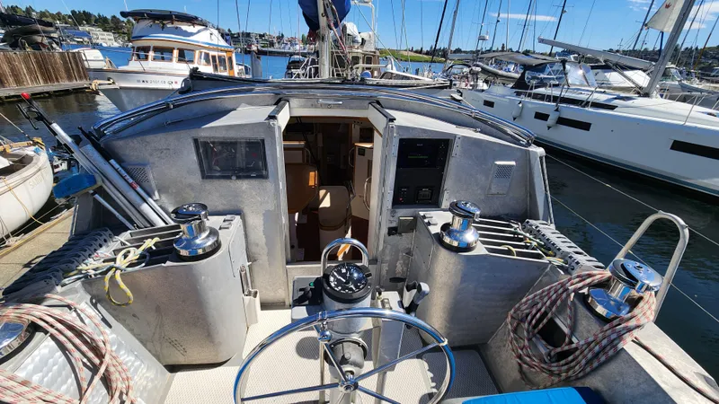 Slide: The Image of 2004 Dudley Dix Jacobs Bros 43 Pilot sailboat cockpit with steering wheel and winches in marina. - 18