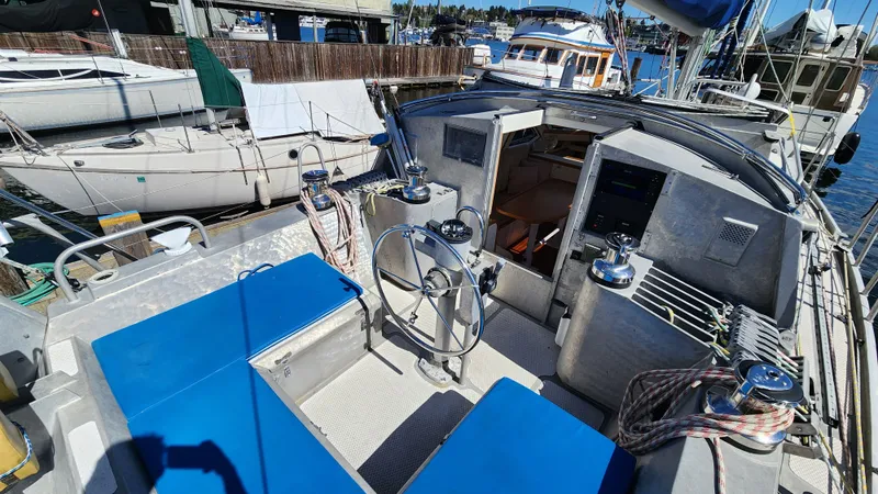 Slide: The Image of 2004 Dudley Dix Jacobs Bros 43 Pilot sailboat cockpit with blue seating and steering wheel. - 17