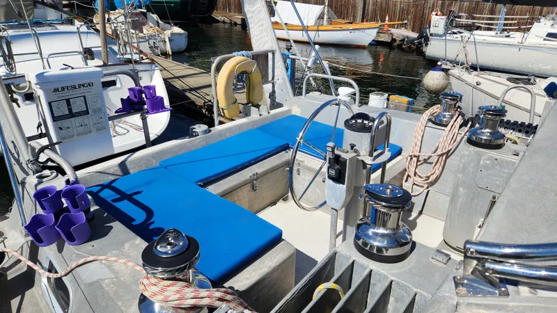 Slide: The Image of 2004 Dudley Dix Jacobs Bros 43 Pilot sailboat cockpit with blue seating and nautical equipment. - 15