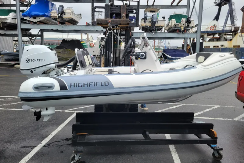 Slide: The Image of 2023 Highfield Sport 330 boat with Tohatsu engine on a lift in a marina. - 16