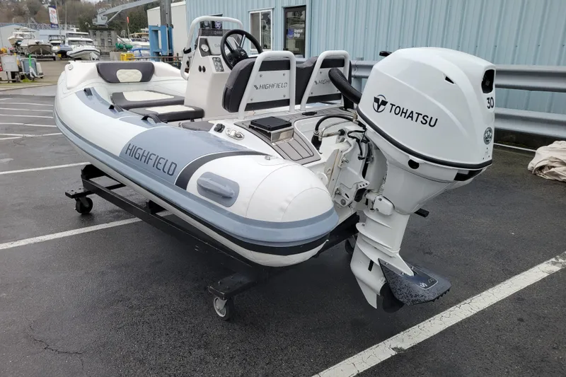 Slide: The Image of 2023 Highfield Sport 330 inflatable boat with Tohatsu 30 outboard motor on a trailer. - 2