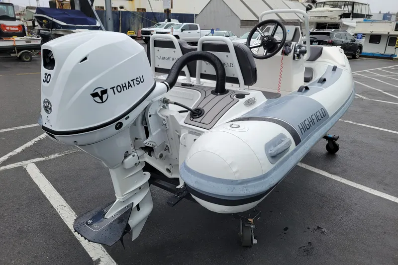 Slide: The Image of 2023 Highfield Sport 330 boat with Tohatsu 30 outboard motor in a parking lot. - 3