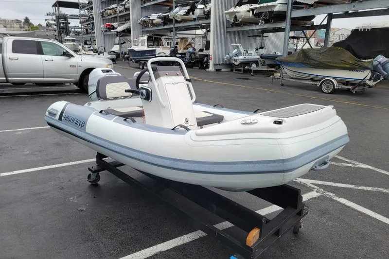 Slide: The Image of 2023 Highfield Sport 330 inflatable boat on trailer in marina parking lot. - 5