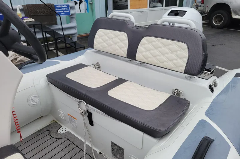 Slide: The Image of 2023 Highfield Sport 330 boat interior with cushioned seating and steering wheel. - 6