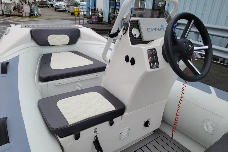 Slide: The Image of 2023 Highfield Sport 330 boat interior with steering wheel and cushioned seating. - 7
