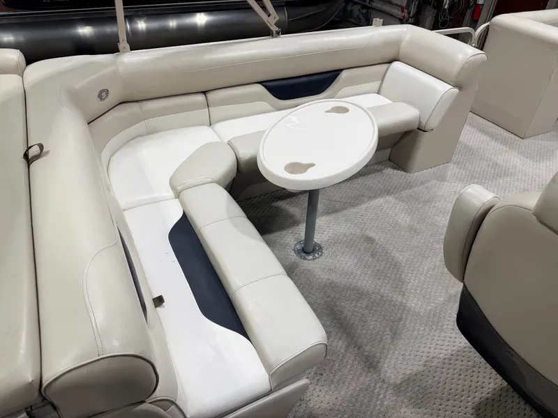 Slide: The Image of 2006 Smoker Craft pontoon with seating area and table, cream interior. - 7