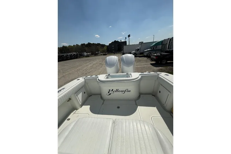 Slide: The Image of 2013 Yellowfin 32 Offshore boat with dual engines, parked outdoors under a clear sky. - 13