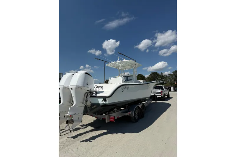 Slide: The Image of 2013 Yellowfin 32 Offshore boat on trailer under clear blue sky. - 23
