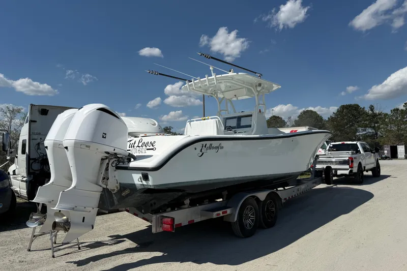 Slide: The Image of 2013 Yellowfin 32 Offshore boat on trailer under clear blue sky. - 24