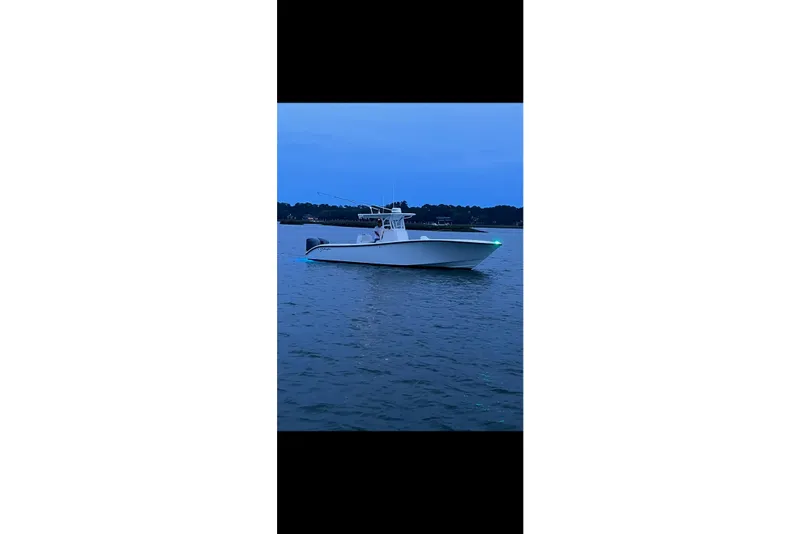 Slide: The Image of 2013 Yellowfin 32 Offshore boat on calm water at dusk. - 25