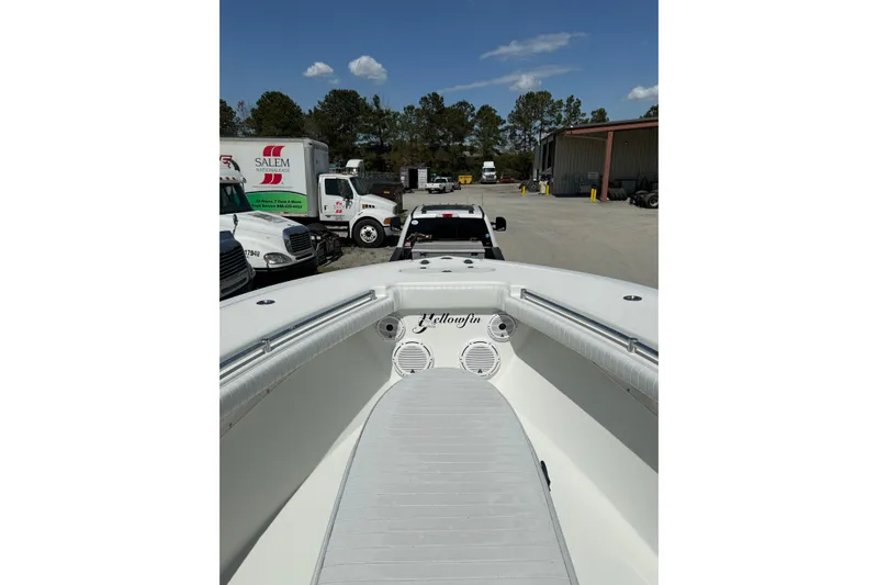 Slide: The Image of 2013 Yellowfin 32 Offshore boat interior with seating and console, parked outdoors. - 4