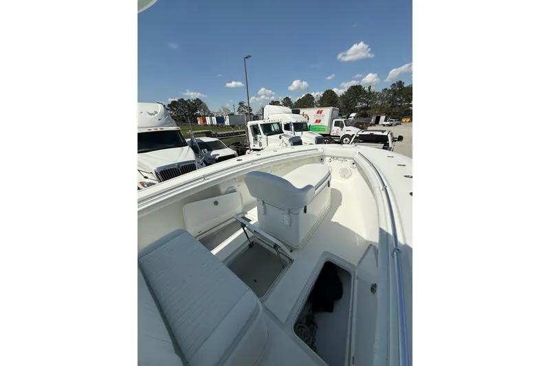 Slide: The Image of 2013 Yellowfin 32 Offshore boat on trailer, parked near trucks and warehouse. - 5