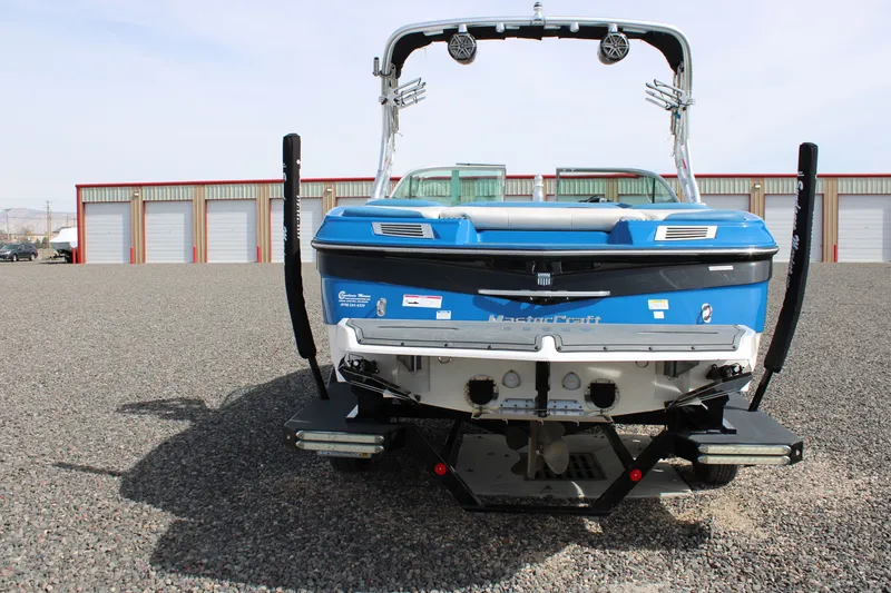 Slide: The Image of Rear view of a blue 2013 MasterCraft X10 boat on gravel. - 13