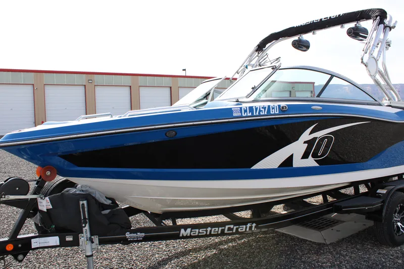 Slide: The Image of 2013 MasterCraft X10 boat on trailer, blue and black, side view. - 3