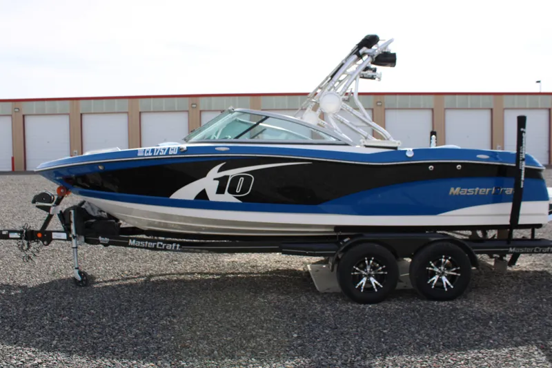 Slide: The Image of 2013 MasterCraft X10 boat on trailer, blue and black, side view. - 4