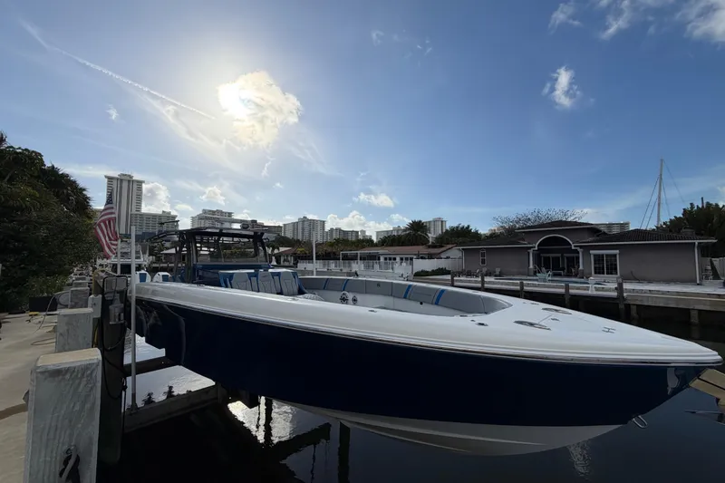 The Image of Midnight Express 43 Open boat docked under a sunny sky, with cityscape background. - 0