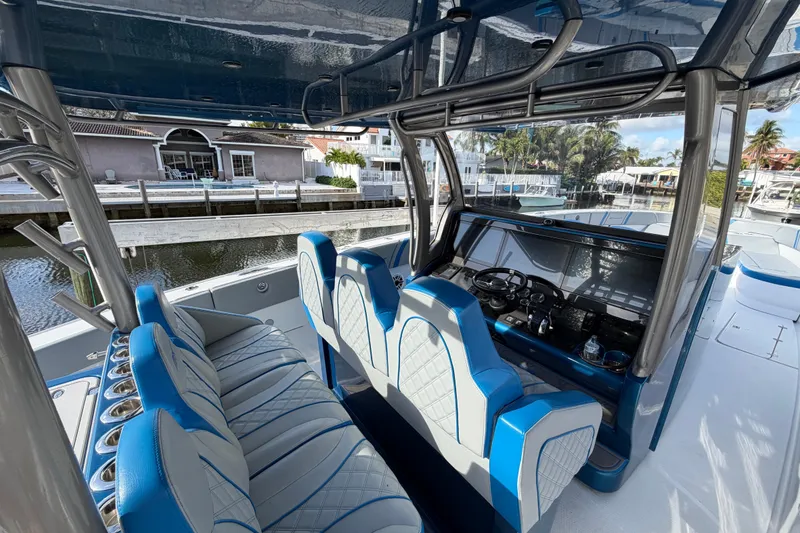 Slide: The Image of Luxury Midnight Express 43 Open boat interior with blue and white seating, docked by waterfront homes. - 4