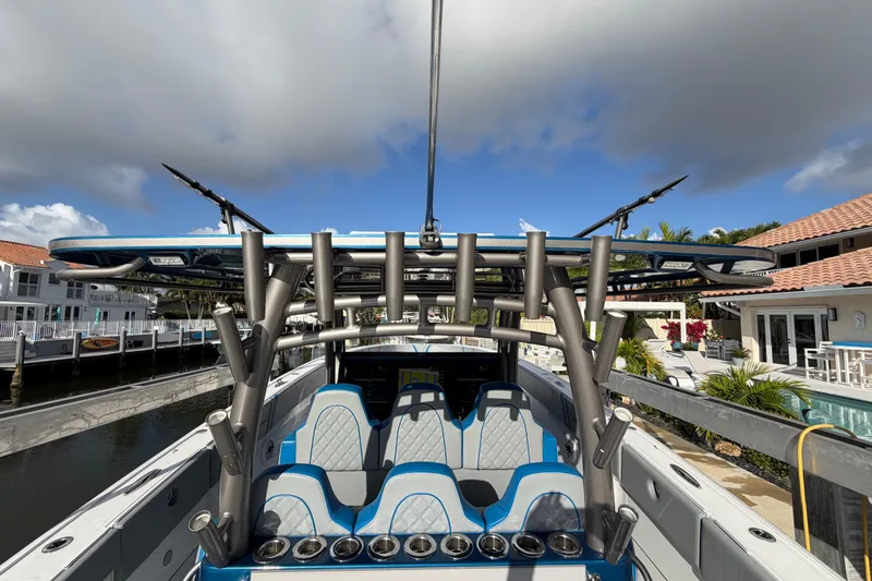 Slide: The Image of Midnight Express 43 Open boat with blue seating and rod holders docked by waterfront homes. - 5