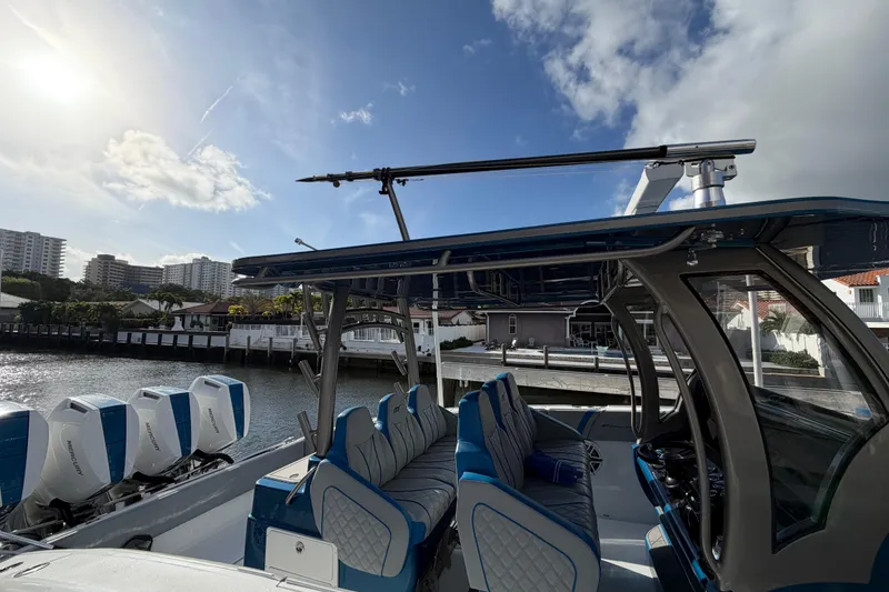 Slide: The Image of Midnight Express 43 Open boat with blue seating and multiple outboard engines docked by waterfront. - 6