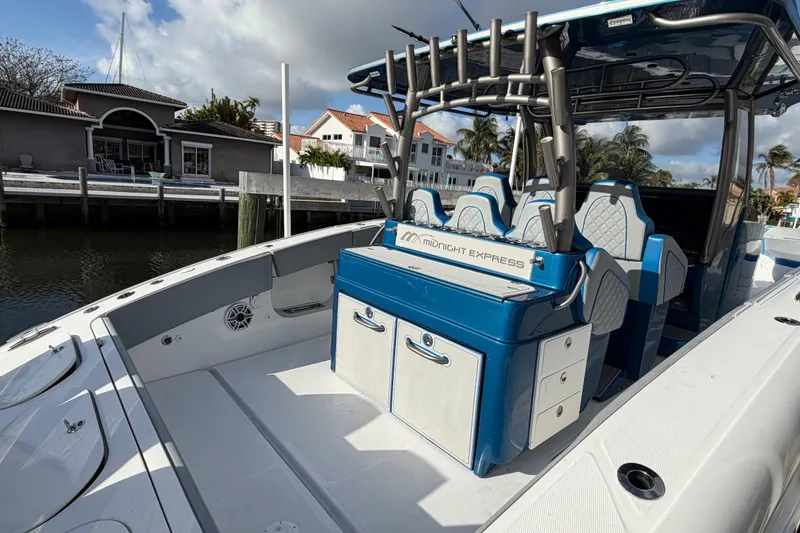 Slide: The Image of Midnight Express 43 Open boat with blue seating, docked near waterfront homes. - 7