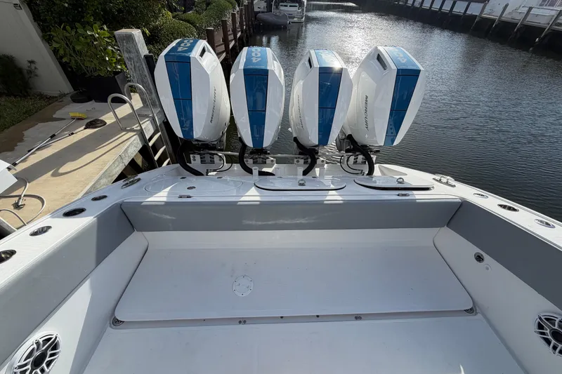 Slide: The Image of Midnight Express 43 Open boat with four powerful Mercury outboard engines docked by the water. - 9