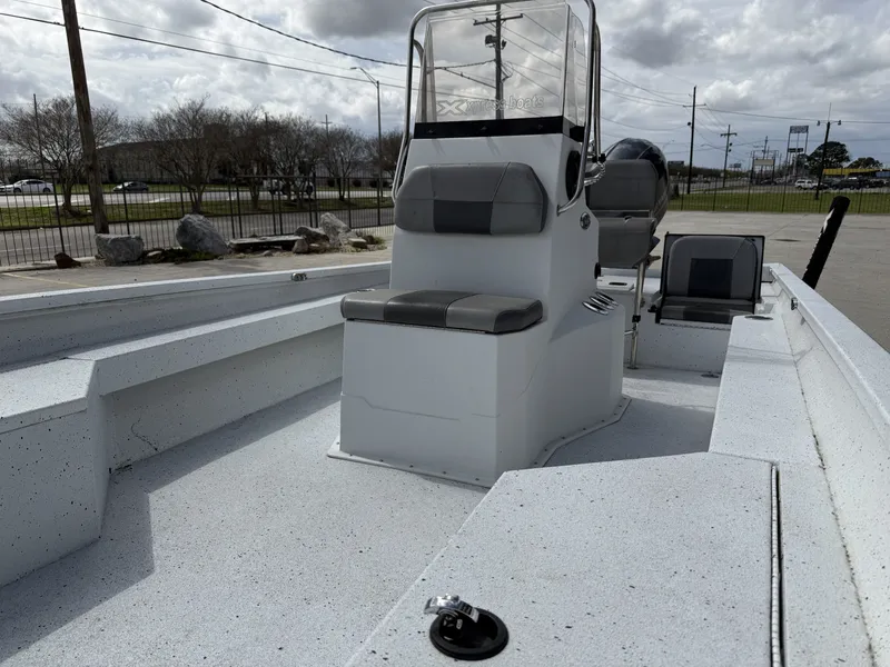 Slide: The Image of 2021 Xpress H24B Bay boat with gray seats and console. - 9