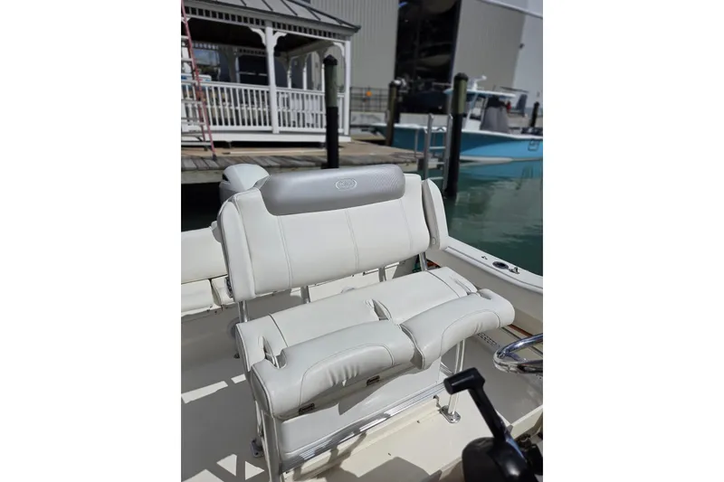 Slide: The Image of 2022 Key West 219 FS boat with white cushioned seating at a marina dock. - 13