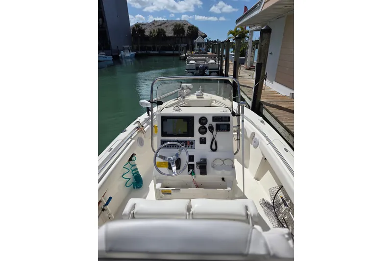 Slide: The Image of 2022 Key West 219 FS boat interior with steering wheel and control panel at dock. - 14