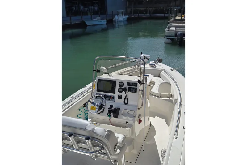 Slide: The Image of 2022 Key West 219 FS boat interior with steering console, docked in marina. - 24