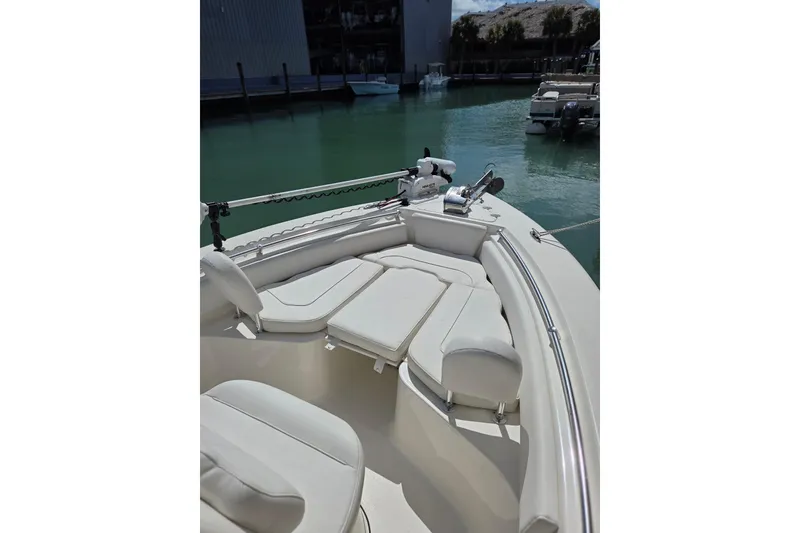 Slide: The Image of 2022 Key West 219 FS boat interior with cushioned seating, docked by calm waters. - 26