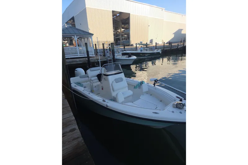 Slide: The Image of 2022 Key West 219 FS boat docked at marina, calm water, industrial building background. - 46
