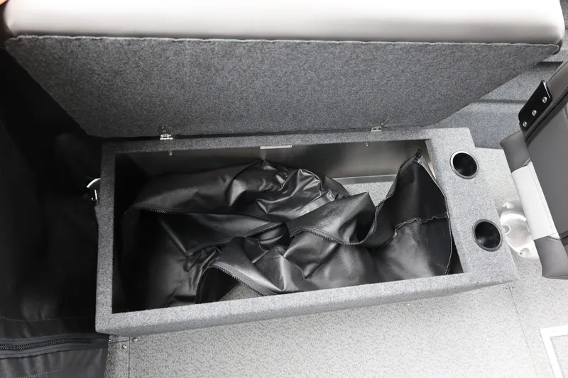 Slide: The Image of Open storage compartment in 2026 Thunder Jet 200 Luxor boat, featuring cup holders and interior lining. - 33