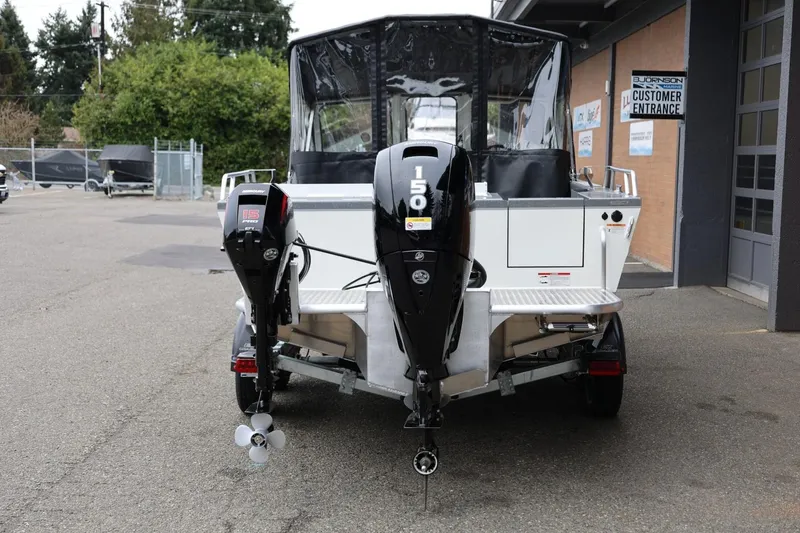 Slide: The Image of 2026 Thunder Jet 200 Luxor boat with dual outboard motors, parked outside a building. - 5