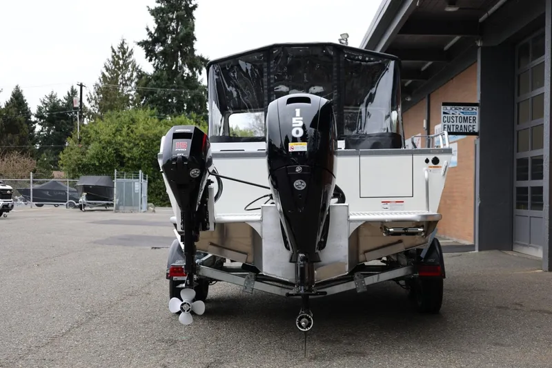 Slide: The Image of 2026 Thunder Jet 200 Luxor boat with dual outboard motors, parked outside a building. - 6