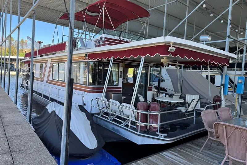 The Image of 1987 Stardust Cruisers 14 x 54 houseboat docked with outdoor seating and canopy. - 0