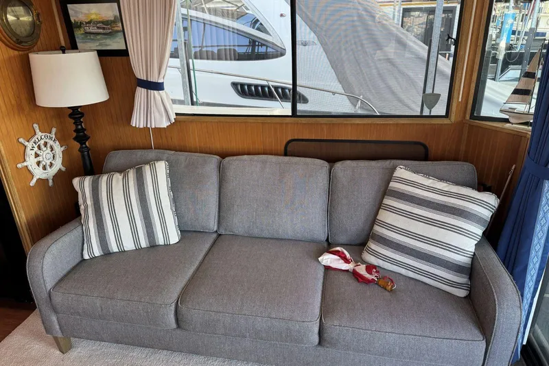 Slide: The Image of Gray sofa with striped pillows in a cozy 1987 Stardust Cruisers houseboat interior. - 15