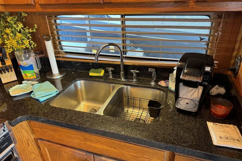 Slide: The Image of Kitchen sink area in a 1987 Stardust Cruisers houseboat with granite countertop and Keurig coffee maker. - 17