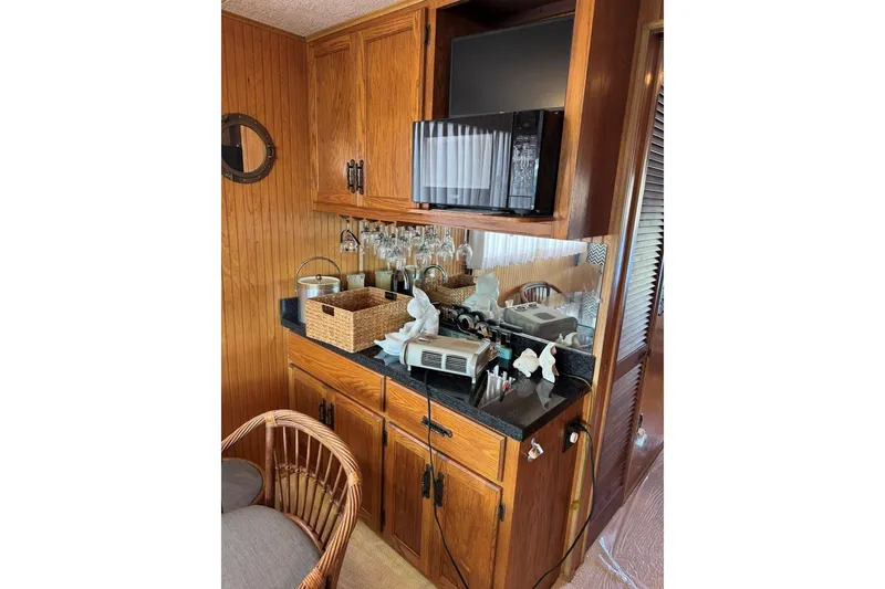 Slide: The Image of 1987 Stardust Cruisers 14 x 54 interior with wooden cabinets, microwave, and countertop accessories. - 19