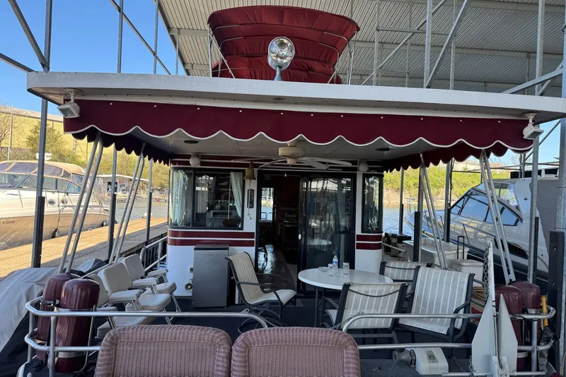 Slide: The Image of 1987 Stardust Cruisers 14 x 54 houseboat with outdoor seating under a canopy. - 2