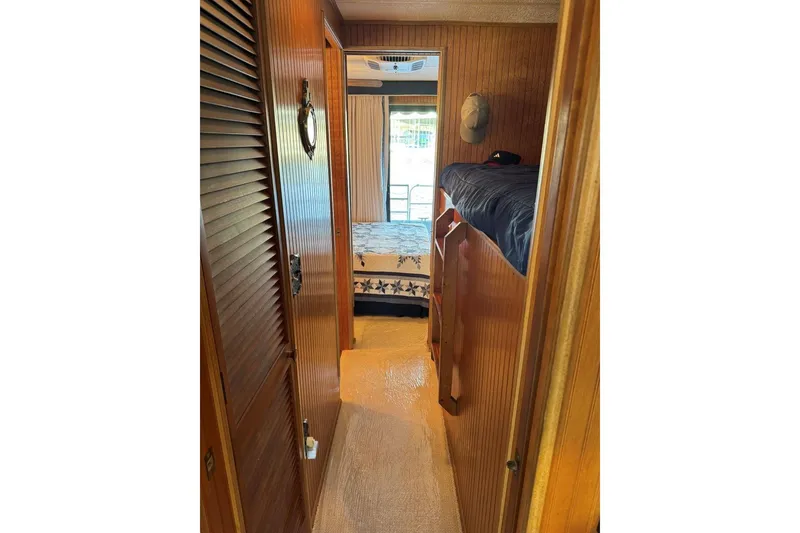 Slide: The Image of Narrow hallway inside 1987 Stardust Cruisers 14 x 54 houseboat with wooden paneling and bunk beds. - 21