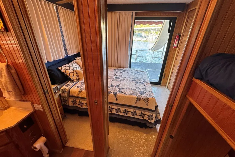 Slide: The Image of Cozy bedroom in 1987 Stardust Cruisers houseboat with quilted bedspread and waterfront view. - 23