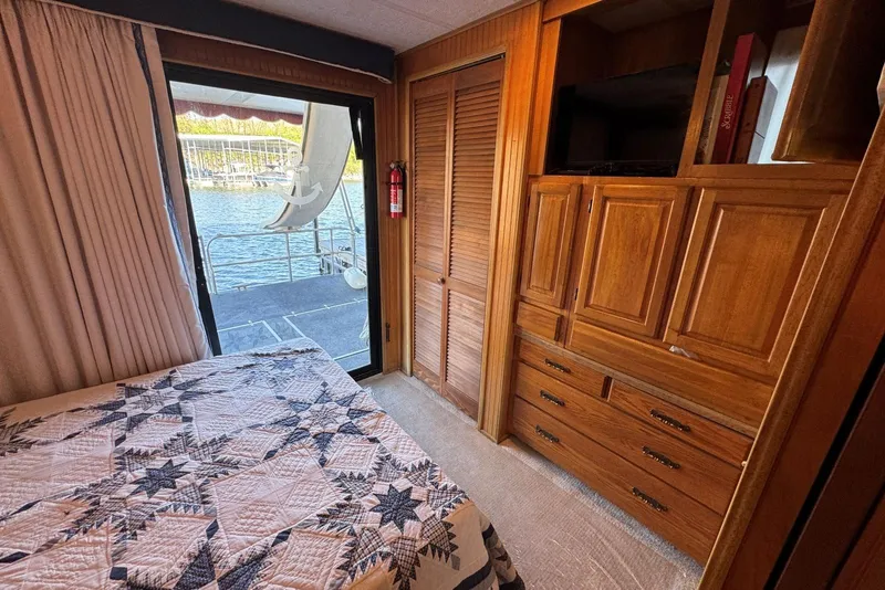 Slide: The Image of Cozy bedroom in 1987 Stardust Cruisers houseboat with wooden cabinetry and water view. - 31