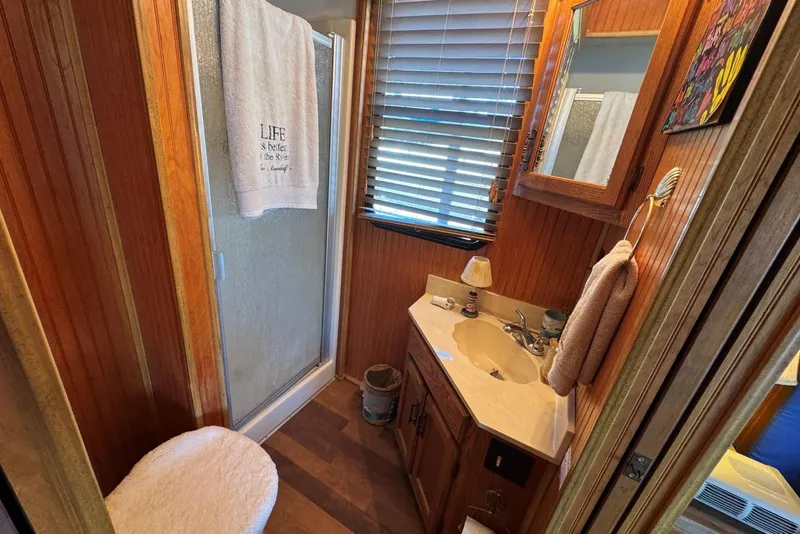Slide: The Image of 1987 Stardust Cruisers bathroom with wood paneling, shower, and sink. - 32